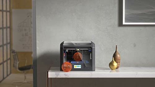 3D printer on a desk with printed objects