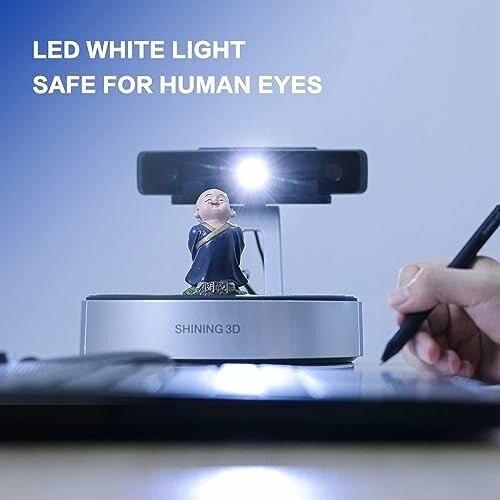 3D scanner with LED light scanning a small figurine.