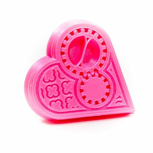 Pink heart-shaped cookie cutter with gear and floral patterns.